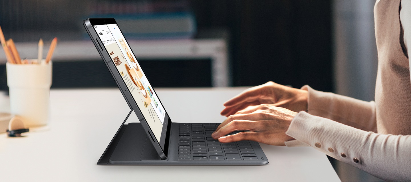 슬림 키보드 북커버를 사용해 갤럭시 탭 S11에서 타이핑하는 모습입니다. 화면에 드로잉 어시스트와 삼성 노트가 나란히 표시되어 있습니다. 세련된 디자인의 키보드가 태블릿 디자인과 잘 어우러져 창의적인 멀티태스킹을 위한 깔끔하고 전문적인 작업 환경을 연출합니다.