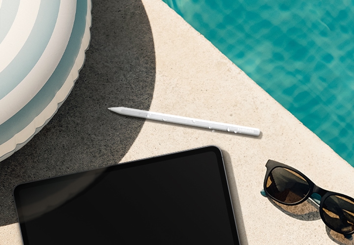 수영장 물가에 물방울이 맺힌 S펜이 놓여 있습니다. 빛을 반사하는 육각형 디자인이 강조되며 뒤쪽에는 삼성 로고가 보입니다. 주변으로는 갤럭시 탭 S11 울트라, 줄무늬 튜브, 선글라스가 함께 배치되어 방수 기능을 강조합니다. 