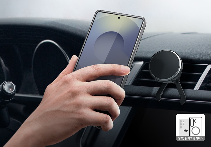 차량 내부에 장착된 차량용 마그넷 무선 충전기 가까이에 스마트폰을 들고 있는 손이 보이고 있습니다.