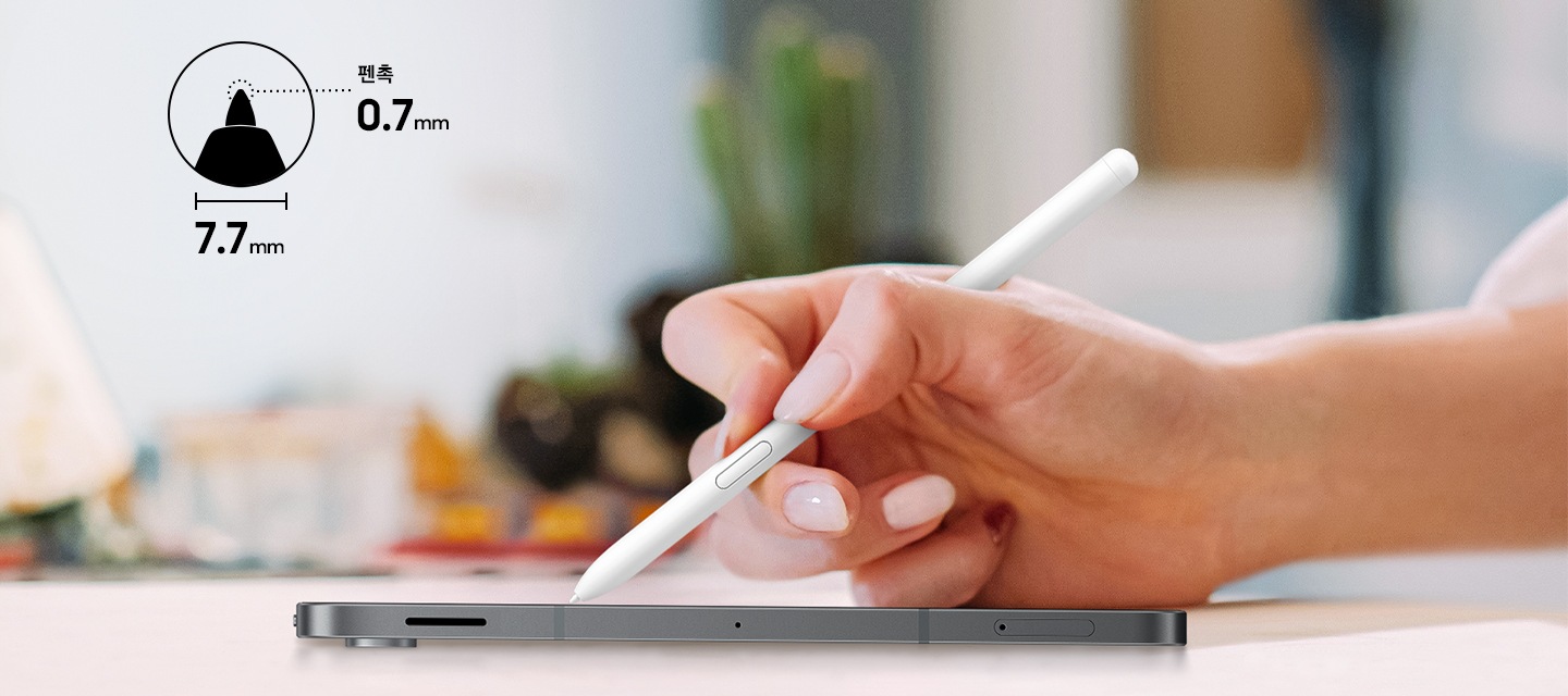 한 손이 S펜을 잡고 평평한 표면에 놓인 갤럭시 S10 라이트에 자신 있게 필기합니다. S펜 버튼이 드러납니다. 왼쪽 상단에는 정밀한 필기를 위한 0.7mm 펜촉과 손에 착 감기는 7.7mm 바디를 강조하는 아이콘이 표시됩니다.