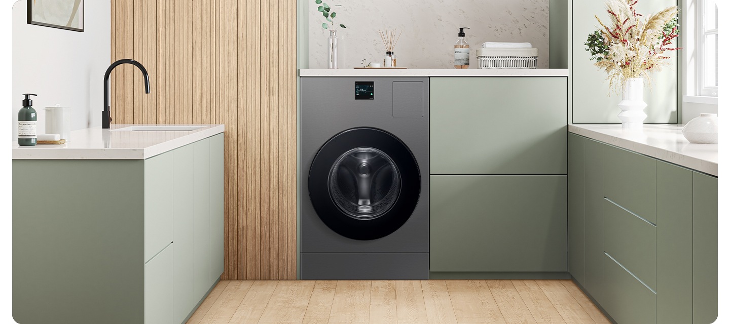 다용도실에 BESPOKE AI 콤보 제품이 가운데 있습니다. 제품 옆에서 수납장 있고 위에는 물건들이 놓여져있습니다. 좌측에는 세면대 있고 우측에는 수납장 위에 꽃병이보입니다