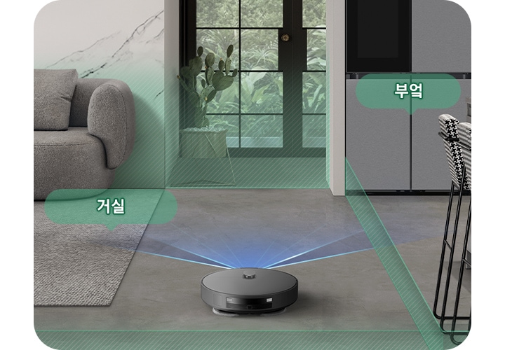 채도가 낮은 색상의 거실과 부엌을 배경으로 Bespoke AI 스팀 울트라의 뒷 모습이 이미지 중간 하단 부분에 있으며, 이미지 왼쪽 부분에는 회색의 카펫트가 카펫트 위에는 더 진한 회색의 소파와 어두운 색상의 우드 테이블이 놓여 있고 소파와 카펫트가 만나는 부분에는 반투명한 초록색 말풍선에 거실이라는 텍스트가 쓰여 있습니다. 이미지 오른쪽 부분에는 체크무늬의 높은 의자 2개가 회색 대리석의 주방 테이블 옆에 배치되어 있고 냉장고가 테이블 왼쪽 부분에 놓여 있으며 냉장고 앞부분에는 반투명한 초록색 말풍선에 부엌이라는 텍스트가 쓰여 있습니다. Bespoke AI 스팀 울트라가 집 안을 스캔해 거실과 주방을 초록색 빗금이 그려진 반투명 박스로 구분하며 각 공간을 인식하는 모습을 보여주고 있습니다.