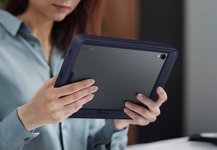 한 여성이 프레임 커버를 장착한 갤럭시 탭 S11을 가로 모드로 사용하고 있습니다.