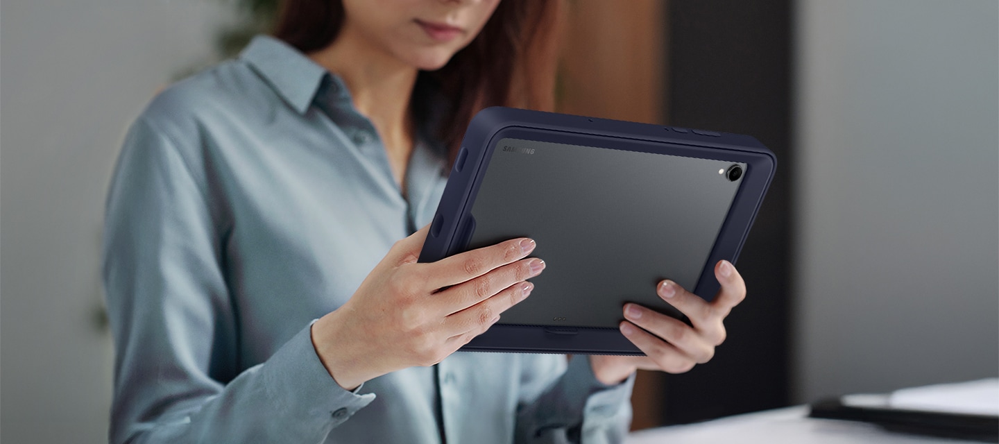한 여성이 프레임 커버를 장착한 갤럭시 탭 S11을 가로 모드로 사용하고 있습니다.