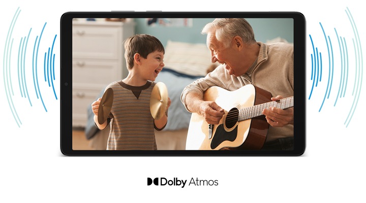 갤럭시 탭 A11이 정면에 나타나고 화면에는 환하게 웃는 소년과 어쿠스틱 기타를 연주하는 노년의 남성이 함께 등장합니다. 태블릿 뒤로는 원형 패턴의 그래픽이 좌우로 퍼져 나가며 사운드 웨이브를 형상화합니다. 갤럭시 탭 A11 하단에는 'Dolby Atomos' 로고가 표시됩니다.