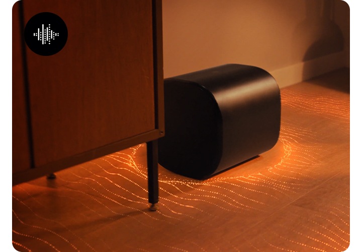 장식장 옆에 놓인 우퍼에서 음향효과가 나오고 있습니다.