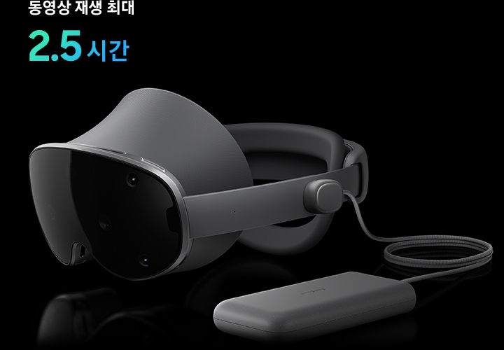 갤럭시 XR에 전원 커넥터로 가벼운 외장 배터리 팩이 연결되어 있으며, 약간 왼쪽으로 향한 채 수평으로 놓여 있습니다.