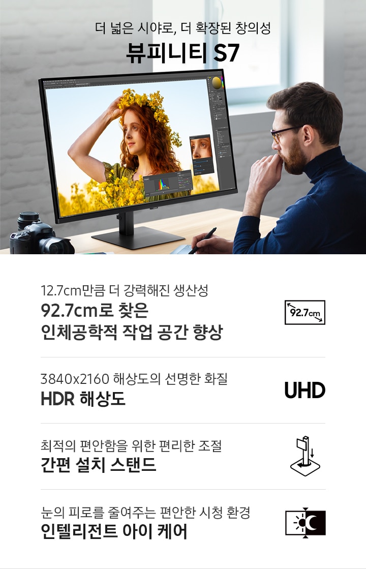 더 넓은 시야로, 더 확장된 창의성 뷰피니티 S7. 남성이 모니터 화면을 보며 작업하고 있는 연출된 이미지 입니다. 이미지 하단에는 뷰피니티 S7 모니터의 특장점이 나열되어 있습니다. 12.7cm만큼 더 강력해진 생산성 92.7cm로 찾은 인체공학적 작업 공간 향상 문구와 아이콘, 3840x2160 해상도의 선명한 화질 UHD 해상도 문구와 아이콘, 최적의 편안함을 위한 편리한 조절 간편 설치 스탠드 문구와 아이콘, 눈의 피로를 줄여주는 편안한 시청 환경 인텔리전트 아이 케어 문구와 아이콘.