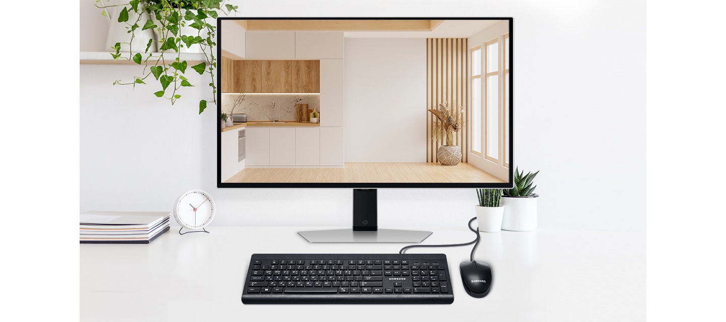 화이트톤의 책상 중앙에 모니터가 있고 모니터 앞에는 유선 키보드와 마우스가 있습니다. 모니터 양쪽으로는 화분으로 꾸며져 있습니다.