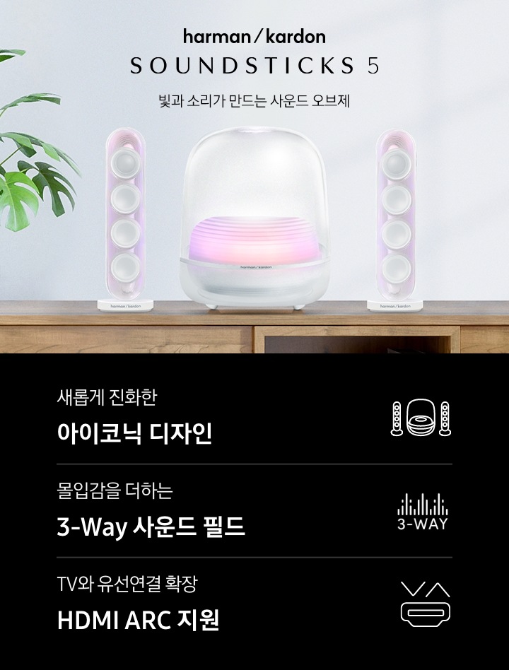 장식장 위에 흰색 스피커가 놓여 있습니다. 스피커 왼쪽에는 화분이 놓여 있으며, 오른쪽에는 하만카돈 로고와 스피커의 모델명 ‘SOUND STICKS 5’와 ‘빛과 소리가 만드는 사운드 오브제‘ 문구가 기재되어 있습니다. 이미지 하단에는 ‘새롭게 진화한 아이코닉 디자인‘, ‘몰입감을 더하는 3-Way 사운드 필드‘, ‘TV와 유선연결 확장 HDMI ARC 지원’ 문구와 아이콘이 있습니다.