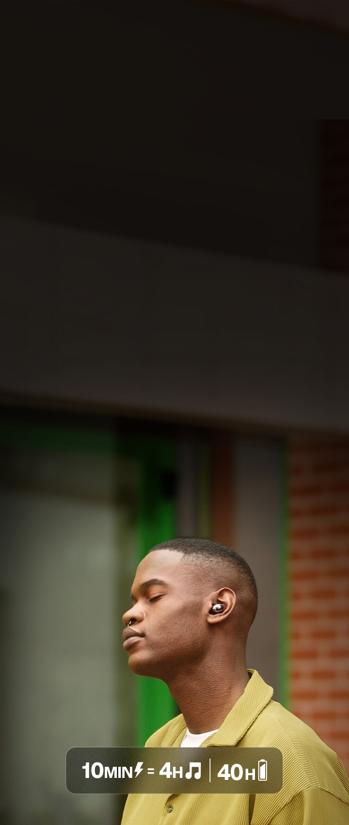 남성이 이어폰을 착용한 상태로 길 위에 서 있습니다.