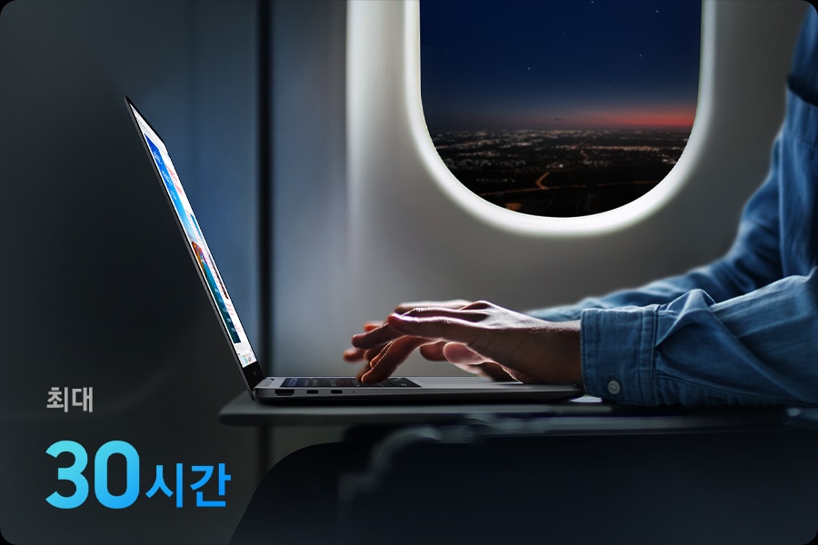 비행기에서 갤럭시 북6 프로를 사용하는 모습입니다. ‘최대 30시간'이라는 문구가 표시되며 장거리 여행에도 문제 없이 오래 지속되는 배터리 수명을 강조합니다.