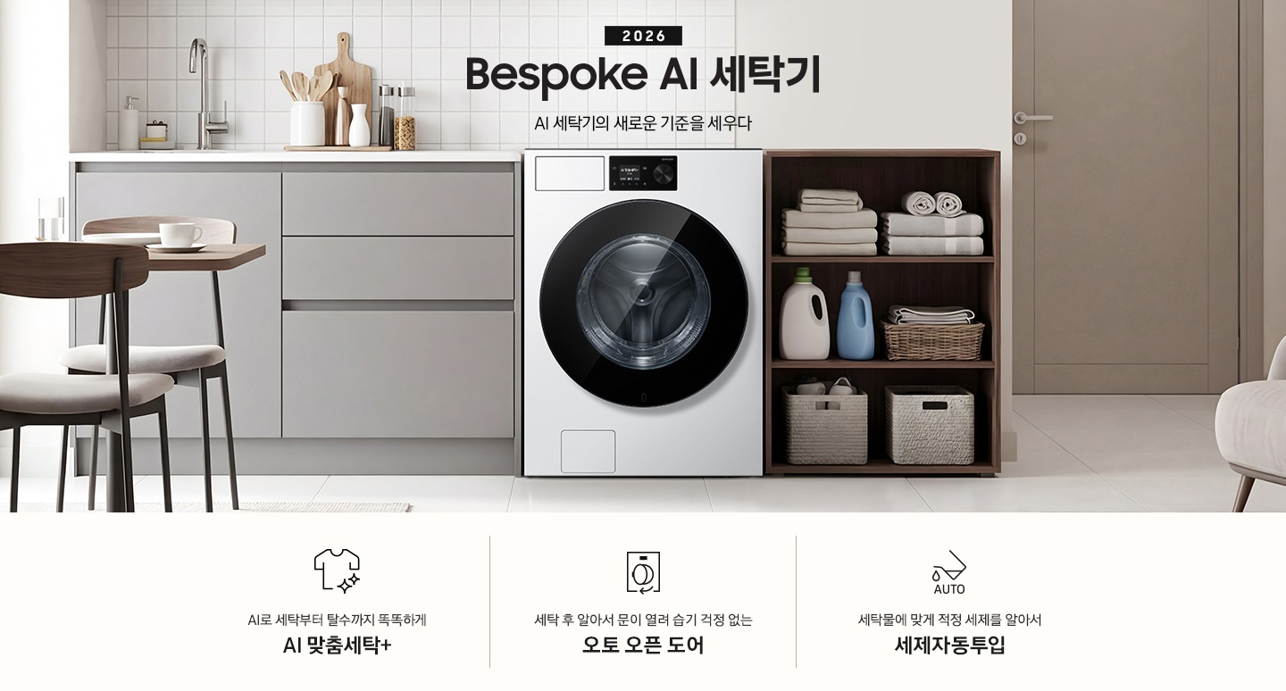 2026 Bespoke AI 세탁기. AI 세탁기의 새로운 기준을 세우다. 벽면에 세탁기가 설치되어 있습니다. 좌측으로는 그레이톤 하부장에 싱크대가 있고 그 위에 도마, 양념통 등 각종 오브제가 놓여있습니다. 하부장 앞에는 2인용 테이블과 의자가 놓여 있습니다. 제품 우측으로는 진한 우드톤 수납장에 수건이 개어져 있고 아래로 세제통과 바구니가 들어있습니다. 그 우측으로는 도어가 보이는 연출된 이미지 입니다. 인테리어컷 하단에는 세탁기 특장점 3가지가 아이콘과 함께 나와있습니다. AI로 세탁부터 탈수까지 똑똑하고 섬세하게 AI 맞춤세탁+ 문구와 아이콘, 세탁 후 알아서 문이 열려 습기 걱정 없는 오토오픈도어 문구와 아이콘, 세탁물에 맞게 적정 세제를 알아서 세제자동투입 문구와 아이콘.