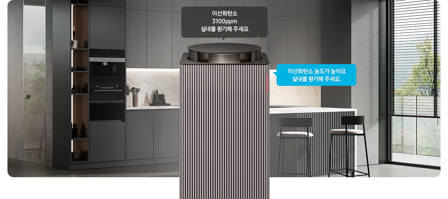 그레이 톤의 주방 전경을 배경으로 오른쪽에는 아일랜드 식탁 의자 2개와 블라인드가 내려진 커다란 창문이 놓여 있습니다. 이미지 가운데에 Infinite AI 공기청정기 상단부가 확대되어 보입니다. 공기청정기 상단에는 알림 창 부분이 이산화탄소 3100ppm 실내를 환기해 주세요. 가 확대되어 놓여 있고 공기청정기 오른쪽으로 음성 안내를 표시하는 파란색 말풍선 안에 이산화탄소 농도가 높아요 실내를 환기해 주세요.라는 문구가 적혀 있습니다.