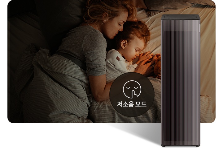 베이지 톤의 침구가 깔린 침대에 누워 회색 이불을 덮고 잠들어 있는 엄마와 아기의 옆모습이 있습니다. 오른쪽 하단에는 Infinite AI 공기청정기가 정면을 바라보고 서 있습니다. 공기청정기 왼쪽에는 검은색 원 안에 입을 가리는 모습을 한 사람 얼굴 아이콘이 있고 하단에는 저소음 모드라는 문구가 적혀 있습니다.