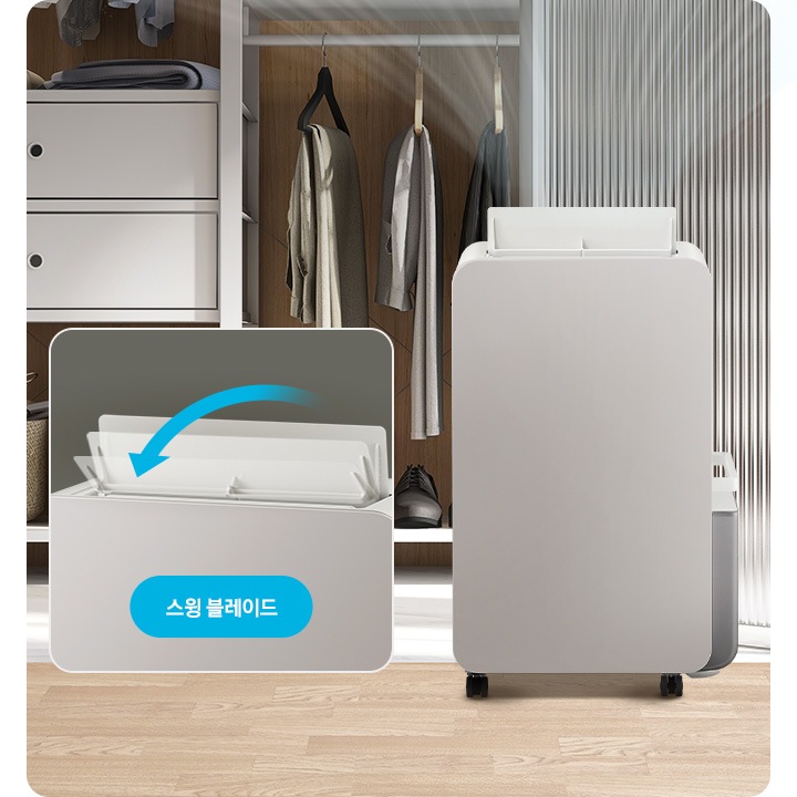 우드 톤의 옷방을 배경으로 이미지 왼쪽 부분에는 옷장이 열려 안에 걸려있는 옷의 하단 부분과 정리된 신발이 자리하고 있습니다. 이미지 중간 부분에는 작동 중인 제습기의 정면 모습이 놓여 있고 제습기 상단으로는 연한 화이트 색상의 선으로 바람이 퍼지는 것을 표현하고 있습니다. 이미지 오른쪽 부분에는 옷장의 문과 방문이 있으며, 그 앞에 제습기 상단 부분에 스윙 블레이드가 확대된 이미지와 함께 이미지 하단 부분에 파란색의 모서리가 동그란 박스 안에 스윙 블레이드 텍스트가 쓰여 있습니다.