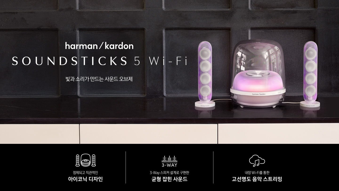 장식장 위에 흰색 스피커가 놓여 있습니다. 오른쪽에는 하만카돈 로고와 스피커의 모델명 ‘SOUND STICKS 5 Wi-Fi’와 ‘빛과 소리가 만드는 사운드 오브제‘ 문구가 기재되어 있습니다. 이미지 하단에는 ‘정제되고 직관적인 아이코닉 디자인‘, ‘3-Way 스피커 설계로 구현한 균형 잡힌 사운드‘, ‘내장 Wi-Fi를 통한 고선명도 음악 스트리밍’ 문구와 아이콘이 있습니다.