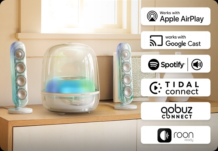장식장 위에 스피커가 놓여 있습니다. 스피커 오른쪽에는 AirPlay, Google Cast, Spotify Connect, Tidal Connec, Qobuz Connect, Roon ready의 아이콘이 있습니다.