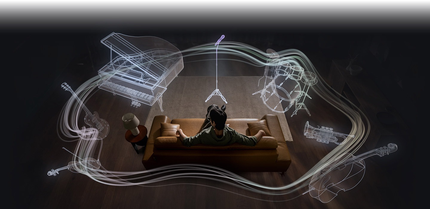 한 남성이 소파에 앉아 있고 그 주위로 다양한 악기들이 원형으로 나타납니다. 악기는 마이크와 마이크 스탠드, 드럼 세트, 트럼펫, 첼로, 바이올린, 일렉트릭 기타, 그랜드 피아노입니다. 악기들을 실루엣으로 표현하여 갤럭시 버즈4에 탑재된 360 오디오 시스템을 강조합니다.