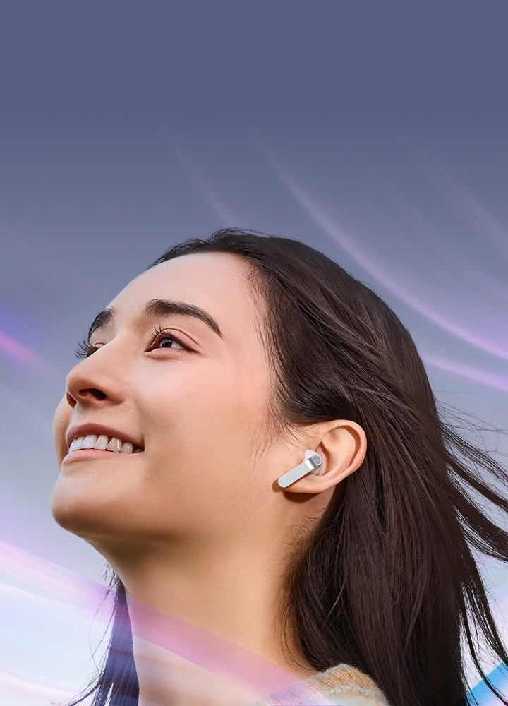 한 여성이 한쪽 귀에 화이트 색상의 갤럭시 버즈4 이어버드를 착용한 모습입니다.