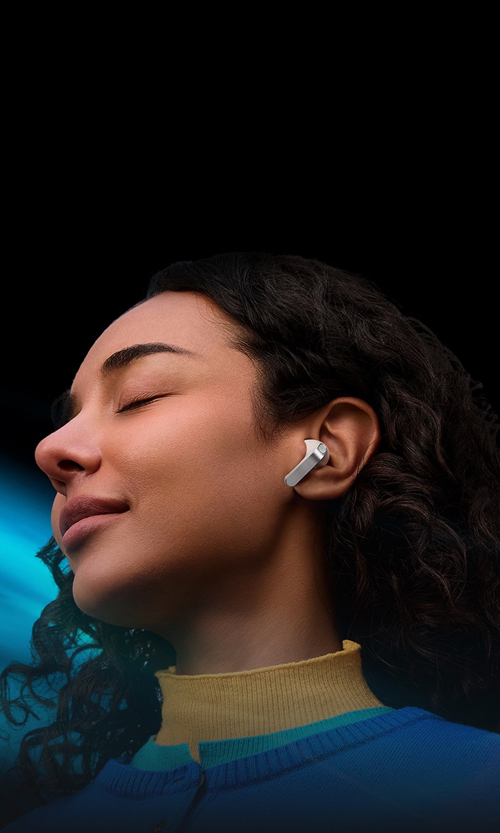 한 여성이 한쪽 귀에 화이트 색상의 갤럭시 버즈4 프로 이어버드를 착용한 모습입니다.