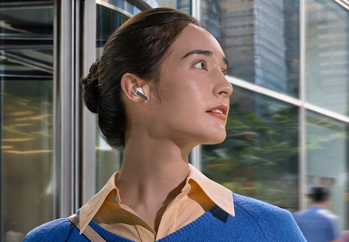 한쪽 귀에 화이트 색상의 갤럭시 버즈4 프로 이어버드를 착용한 여성이 오른쪽으로 고개를 향하고 있습니다.