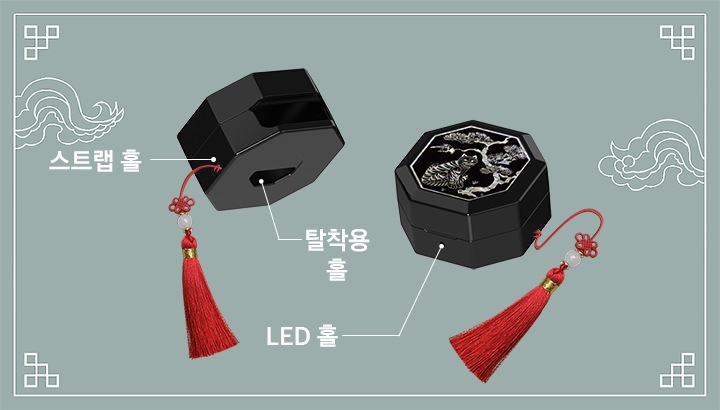 푸른색 배경에 전통 문양 이 그려져 있고, 갤럭시 버즈4｜버즈4 프로 케이스 (호랑이 전통 문양) 두 개가 있습니다. 좌측 제품은 뒤쪽의 좌측 하단을 향하고 있고 우측의 스트랩 홀과 하단의 탈착용 홀이 드러나 있으며 각각에 맞는 텍스트와 선이 이어져 있습니다. 우측의 제품은 앞면의 LED 홀이 드러나 있고 해당 텍스트와 선이 이어져 있습니다.