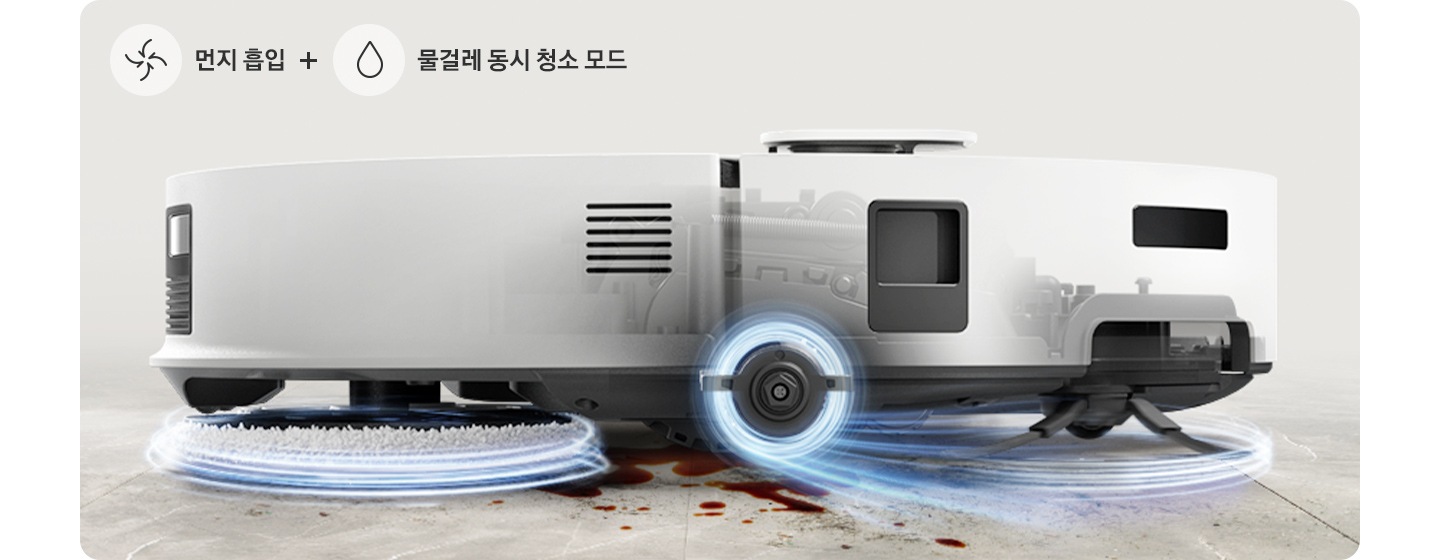 브라운 색상과 연한 회색이 섞인 대리석 바닥에 Bespoke AI 스팀 플러스의 옆모습이 놓여있고 각각 뒷부분의 물걸레와 앞부분의 브러시가 동시에 청소하고 있는 이미지입니다. 물걸레와 브러시가 각각 푸른빛으로 된 선으로 감싸져 있어 돌아가고 있는 모습을 표현하고 있으며, 이미지 왼쪽 하단 부분에는 중간으로 빨려 들어가는 화살표와 물방울 아이콘이 중간에 +를 두고 나열되어 있고 아이콘 오른쪽 부분에는 먼지 흡입 + 물걸레 동시 청소 모드 텍스트가 쓰여있습니다.