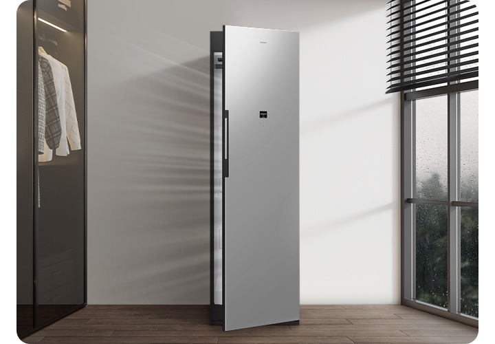 벽면에 설치된 에어드레서 문이 살짝 열려있고 공기가 통하는 모습이 나와 있고 제품 좌측에 붙박이장 행거가, 우측에 창문에 블라인드가 살짝 쳐져 있는 연출된 이미지입니다.