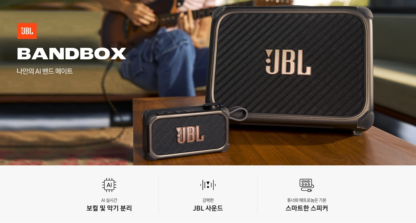 테이블 위에 BAND BOX TRIO와 SOLO가 놓여 있습니다. 그 뒤로는 소파에 앉아 기타를 연주하는 사람이 있습니다. 왼쪽 상단에는 JBL 로고와 모델명인 ‘BANDBOX’와 ‘나만의 AI 밴드 메이트’ 문구가 기재되어 있습니다. 이미지 하단에는 ‘AI 실시간 보컬 및 악기 분리‘, ‘강력한 JBL 사운드‘, ‘튜너와 메트로놈은 기본 스마트한 스피커‘ 문구와 아이콘이 있습니다.