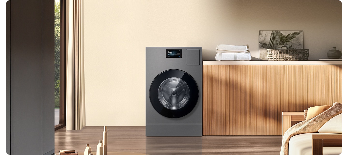 베이지색 벽면에 AI 콤보가 설치되어 있습니다. 좌측으로는 창 밖으로 식물이 보여집니다. 우측으로는 우드톤 하부장 위에 수건 등 다양한 오브제가 놓여있는 연출된 인테리어 이미지 입니다.