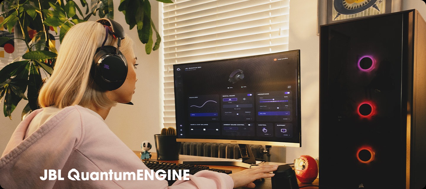 헤드폰을 착용한 여성이 컴퓨터로 JBL QuantumENGINE 대시보드를 보고 있습니다.