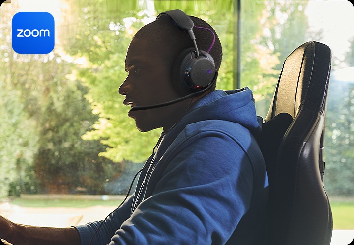 헤드폰을 착용한 남성이 의자에 앉아 있습니다.