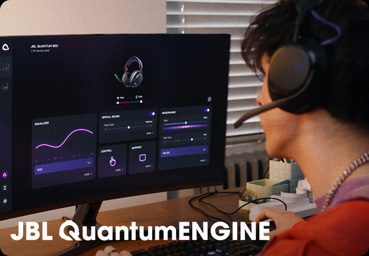 헤드폰을 착용한 남성이 컴퓨터로 JBL QuantumENGINE 대시보드를 보고 있습니다.