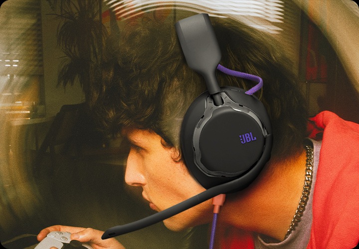 케이블이 연결된 헤드폰을 착용한 남성이 게임을 하고 있습니다.