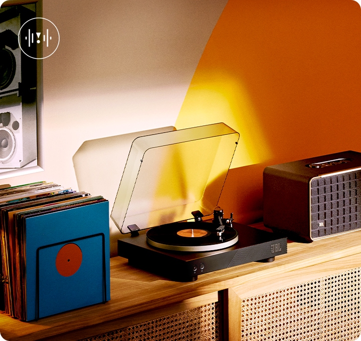 장식장 위 가운데 제품이 놓여 있습니다. 왼쪽으로는 LP가 놓여 있고, 오른쪽에는 블루투스 스피커가 놓여 있습니다.