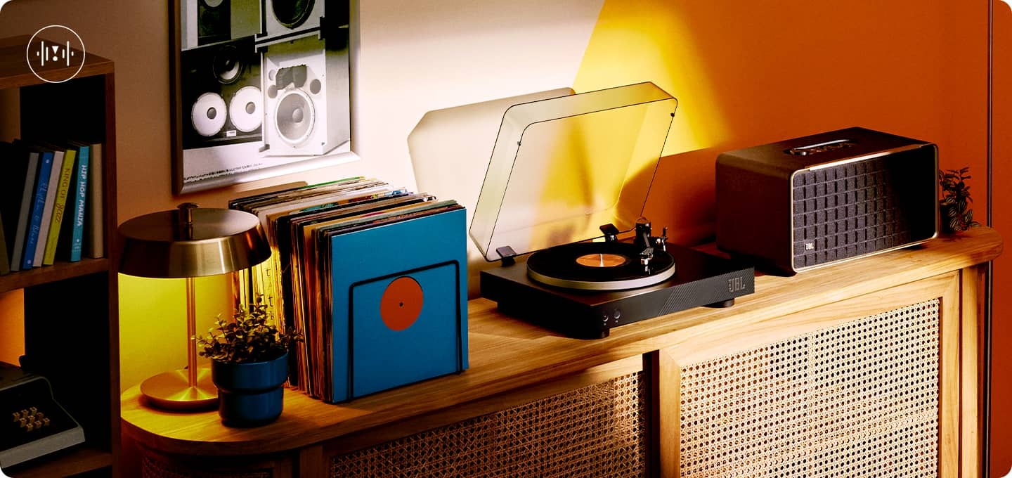 장식장 위 가운데 제품이 놓여 있습니다. 왼쪽으로는 LP가 놓여 있고, 오른쪽에는 블루투스 스피커가 놓여 있습니다.