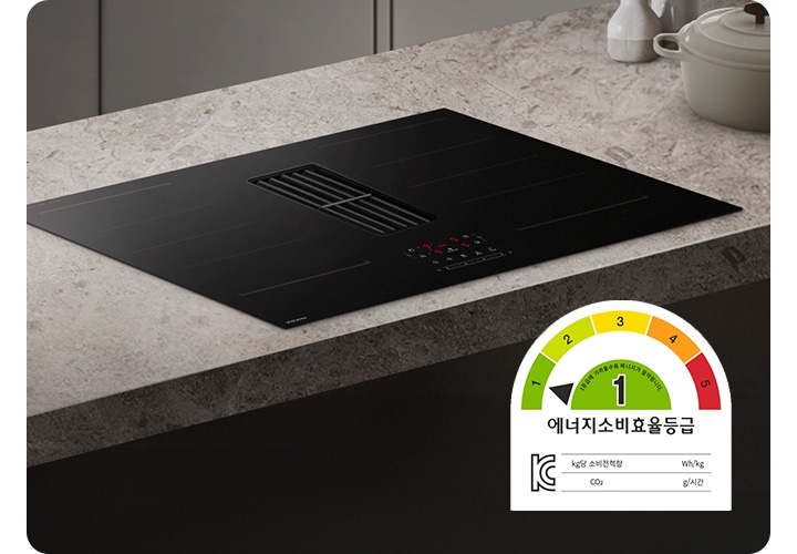 어두운 베이지 톤의 주방을 배경으로 이미지 왼쪽 하단 부분에는 에너지 소비효율 1등급 로고가 노출되어 있고 이미지 중간 부분에는 어두운 베이지 색상의 상판과 설치된 Infinite Line 후드일체형 인덕션이 있습니다. 인덕션 오른쪽 부분에는 아이보리 색상의 냄비와 화병 2개가 겹쳐 놓여 있습니다.