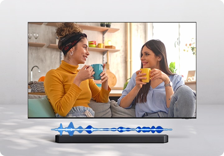 TV에 여성 두명이 대화하는 화면이 보입니다. 하단에는 사운드바 그래픽효과가 보입니다.