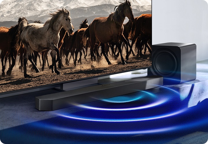 TV 앞에 사운드바가 설치되어 있으며, 사운드바에서 음향효과가 나오고 있습니다.