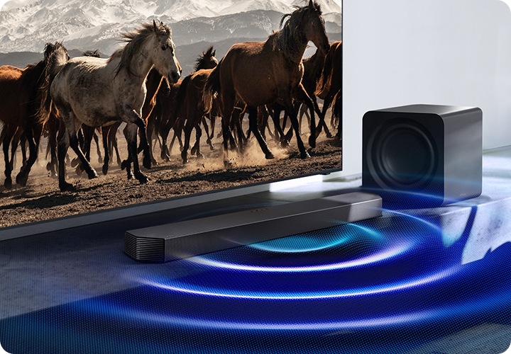TV 앞에 사운드바가 설치되어 있으며, 사운드바에서 음향효과가 나오고 있습니다.