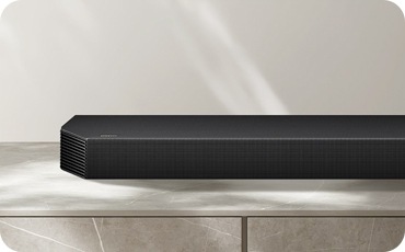 장식장 위에 놓인 사운드바가 놓여 있으며, 사운드바의 왼쪽이 확대되어 있습니다.