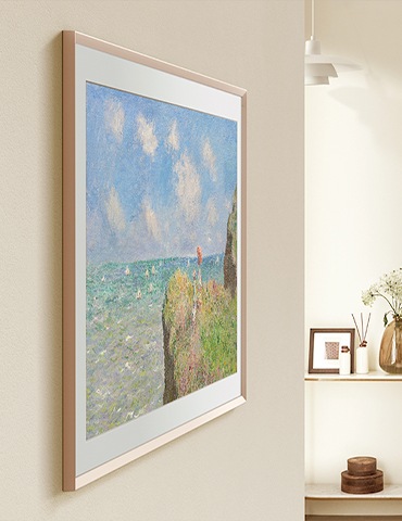 벽에 The Frame이 설치되어 있으며, 화면에는 바다와 절벽이 보이는 이미지가 보여지고 있습니다.