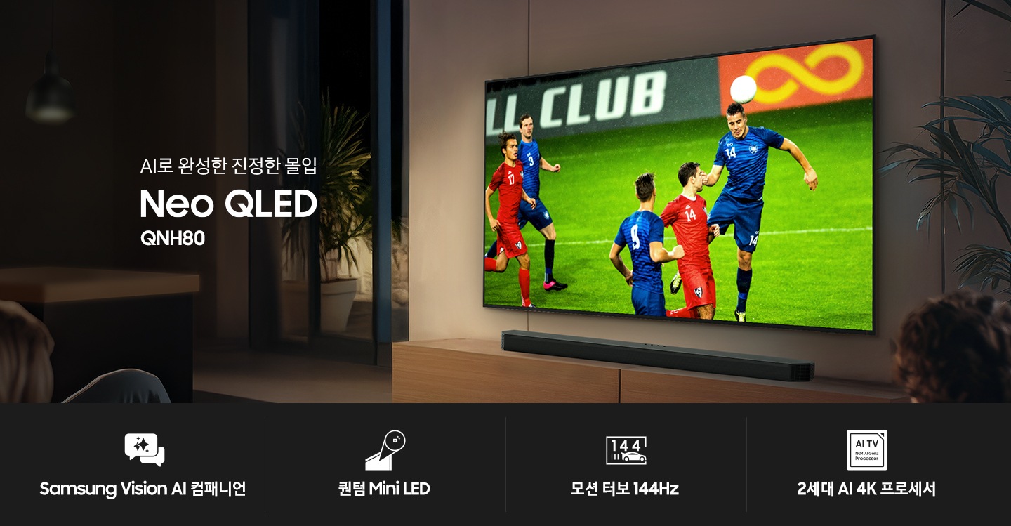 거실 벽에 TV가 설치되어 있습니다. TV 화면에는 축구 경기가 보여지고 있습니다. TV 하단에는 장식장이 있으며, 장식장 위에는 사운드바가 놓여 있습니다. TV 앞에는 테이블과 소파가 놓여 있습니다. 테이블 위에는 콜라와 피자, 과자가 놓여 있으며, 소파에는 사람들과 강아지가 앉아서 TV 화면을 보고 있습니다. 이미지 왼쪽 중간에는 ‘AI로 완성한 진정한 몰입‘, Neo QLED’, ‘QNH80’ 문구가 기재되어 있습니다. 이미지 하단에는 ‘Samsung Vision AI 컴패니언’, ‘퀀텀 Mini LED’, ‘모션 터보 144Hz’, ‘2세대 AI 4K 프로세서’ 문구와 아이콘이 있습니다.