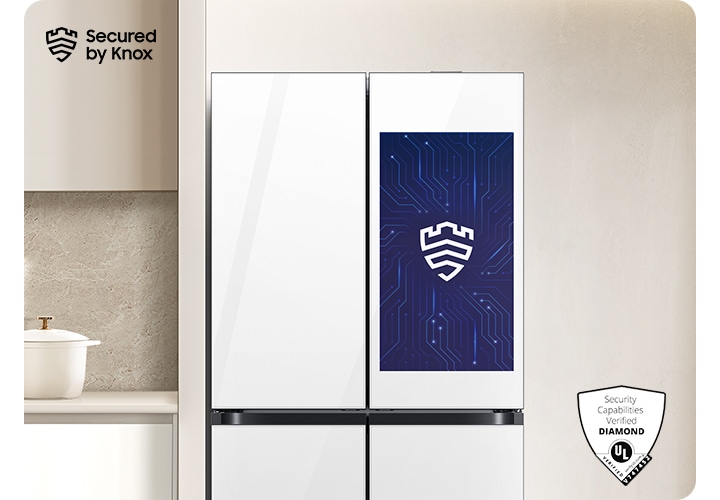 베이지톤 벽면에 패밀리허브 냉장고가 설치되어 있고 스크린 부분에 Knox 보안 로고가 나와있는 연출된 이미지 입니다. 냉장고 좌측에는 화이트톤 하부장 위 냄비, 도마 등 오브제가 놓여있고 우측에는 통창이 약간 나와있는 연출된 이미지입니다.