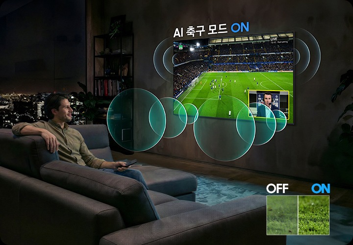 남성이 소파에 앉아서 벽에 설치된 TV를 보고 있습니다. TV 화면에는 축구 경기가 보여지고 있습니다.