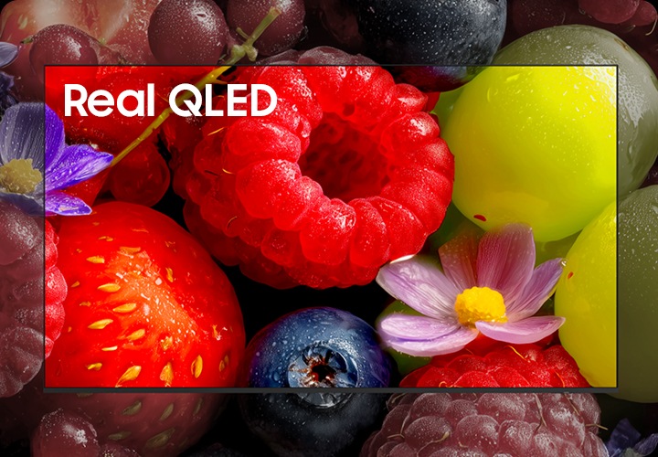 TV화면에 과일들이 보여지고 있으며, TV 중간에 ‘Real QLED’라고 표시된 부분의 과일의 색상이 선명합니다.