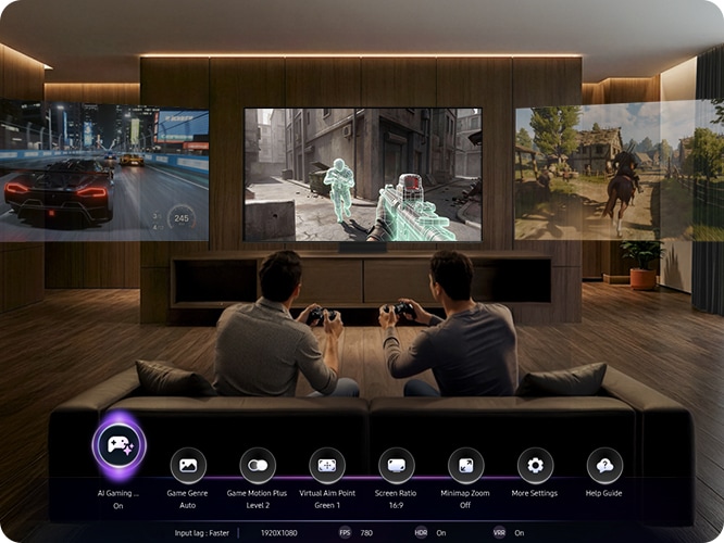 남성 두명이 소파에 앉아서 게임을 하고 있습니다. TV 화면에는 게임 화면이 보여지고 있습니다.