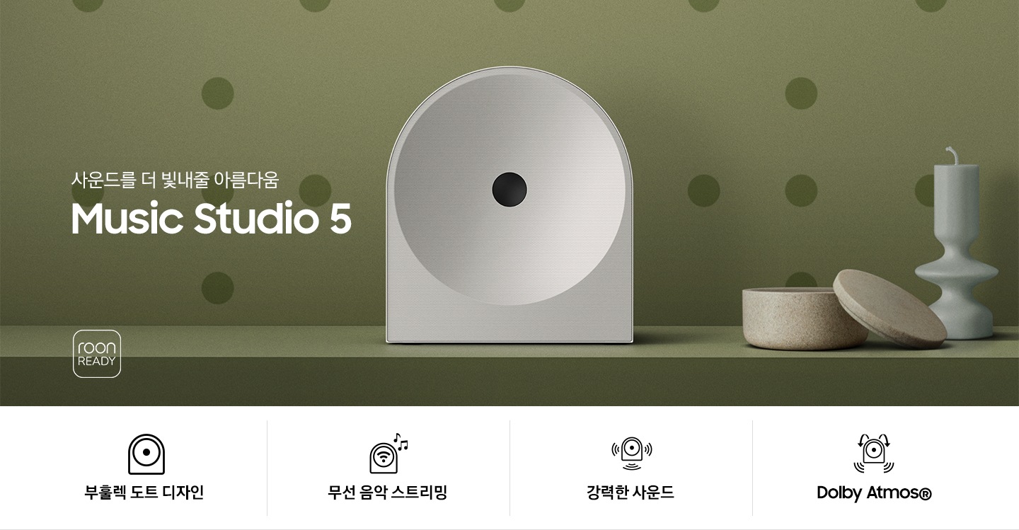 녹색 벽 앞에 스피커가 놓여 있습니다. 스피커 오른쪽에는 촛대와 보석함이 놓여 있으며, 왼쪽에는 ‘사운드를 더 빛내줄 아름다움 Music Studio 5’ 문구가 있고 그 아래에는 ‘roon READY’ 아이콘이 있습니다. 이미지 하단에는 ‘부훌렉 도트 디자인’, ‘무선 음악 스트리민‘, ‘강력한 사운드‘, ‘Dolby Atmos®’ 문구와 아이콘이 있습니다.