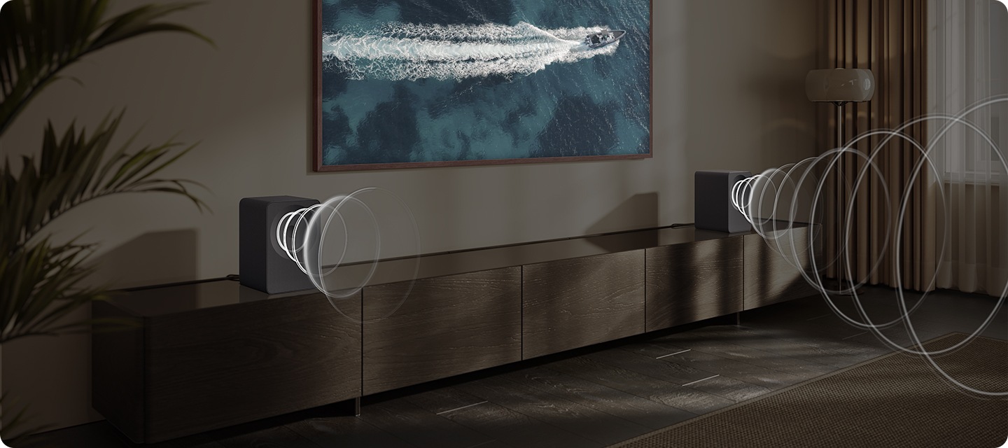 벽에 TV가 설치되어 있으며, 화면에는 바다 위에 요트가 지나가고 있습니다. TV 아래는 장식장이 놓여 있으며, 장식장 양 끝에는 음향효과가 나오고 있는 스피커가 각각 놓여 있습니다.